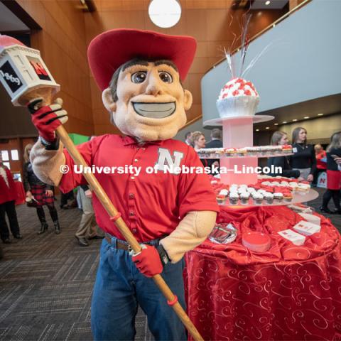 Herbie holds the new mace that was created for the Chancellor to carry at commencement. The mace features the cupola from Love Library along with an ash wood handle. The mace was created at Innovation Campus using a 3D printer and other tools from the UNL makerspace. Everyone was invited to enjoy a cupcake and join in the festivities with their Husker friends at the Wick Alumni Center, Friday February 15th. The Nebraska Charter was available to view, along with other historical items. Copies of Dear Old Nebraska U could be purchased and signed. Charter Day at the Wick Alumni. February 15th, 2019. Photo by Gregory Nathan / University Communication.